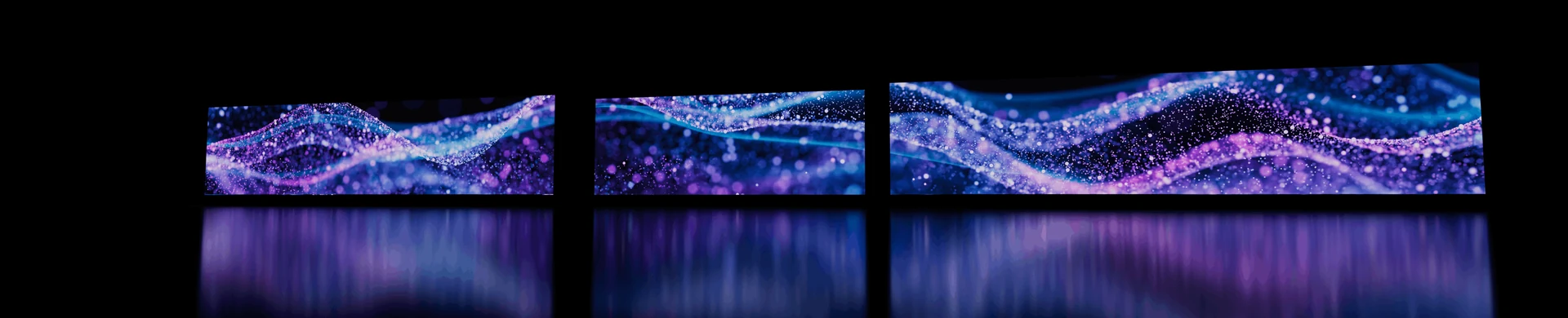Three panoramic particle displays reflected on a dark floor